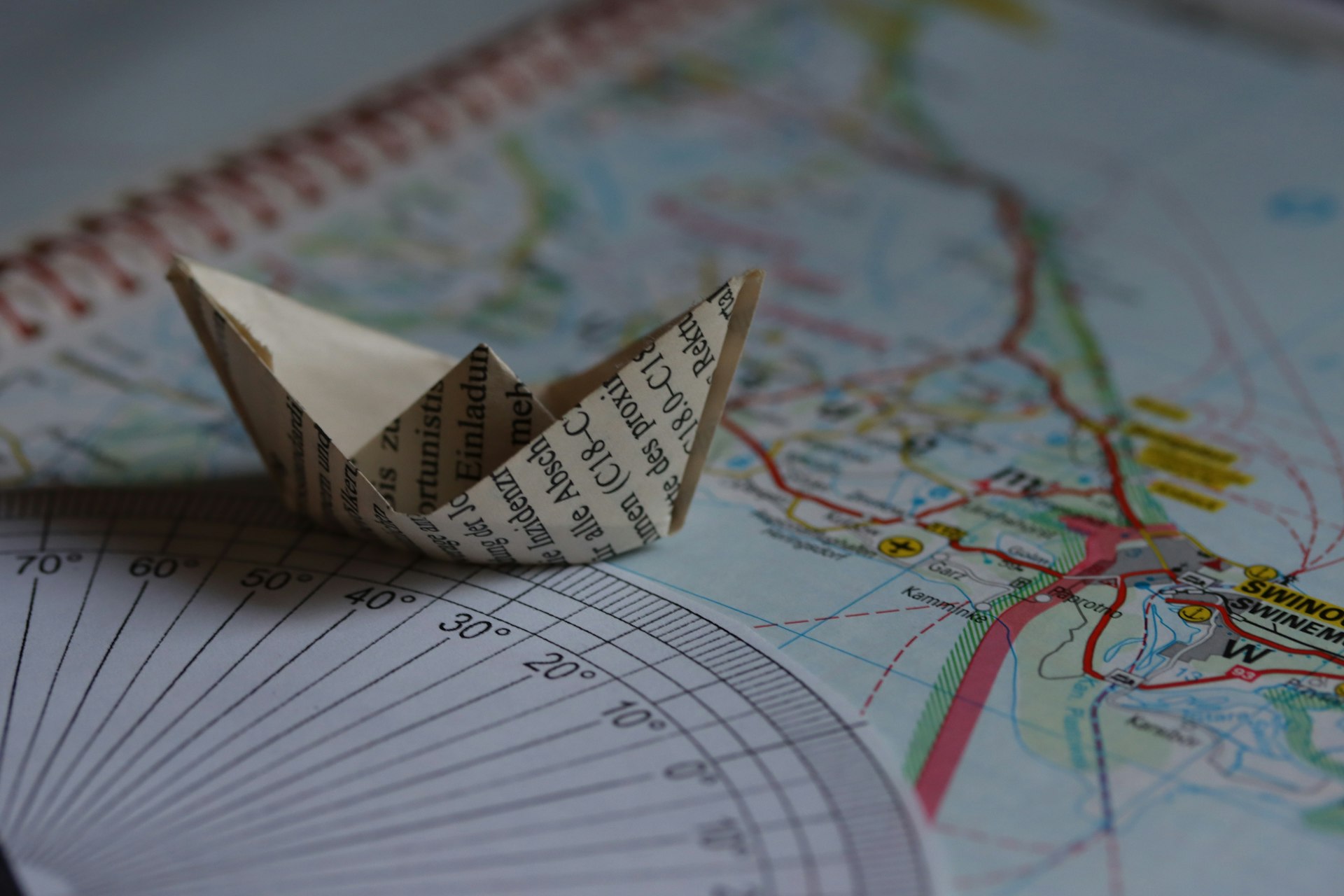 A paper boat sits on a map.